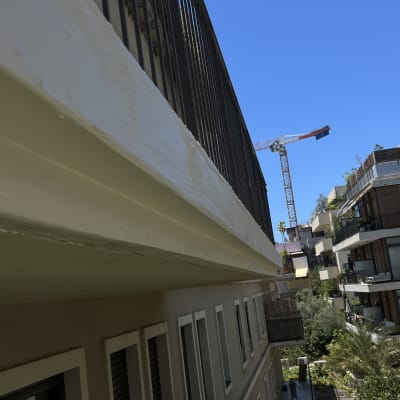 מנוף בנייה ליד בניין מגורים עם מרפסות