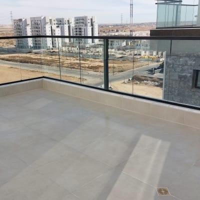 מרפסת עם רצפה נקייה ומעקה זכוכית