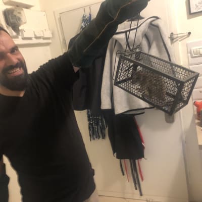 אדם מחזיק מלכודת עם מכרסם בתוכה