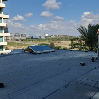 גג אטום עם יריעות ביטומניות ושני קולטי שמש