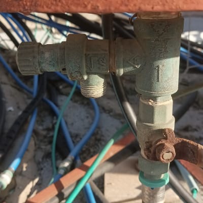 צינור כחול מחובר לשסתום מתכת חלוד