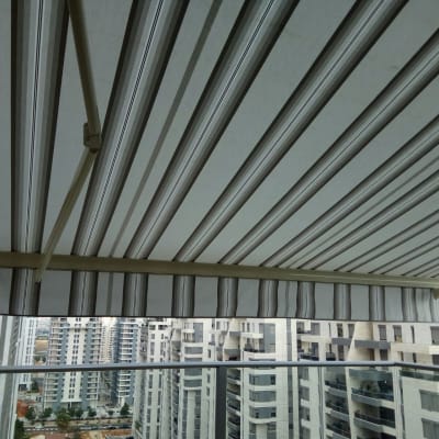 סוכך בד פסים אפור ולבן במרפסת