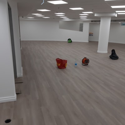 רצפת פרקט בחדר עם תקרה מוארת וכלים על הרצפה