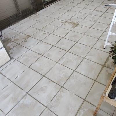 רצפה מרוצפת עם סימני רטיבות ודלי צבע