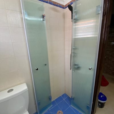 מקלחת עם דלתות זכוכית ומקלחת ראש עגולה