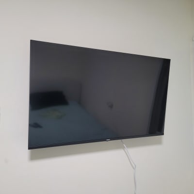 טלוויזיה מותקנת על קיר עם שלט רחוק