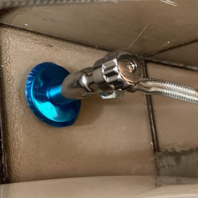 שסתום מתכת עם צינור גמיש על קיר אריחים