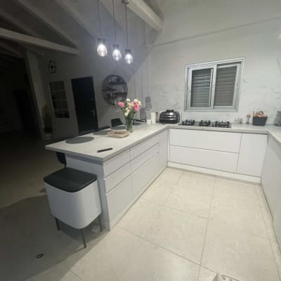 מטבח מודרני עם כיריים, טוסטר ופרחים על השיש