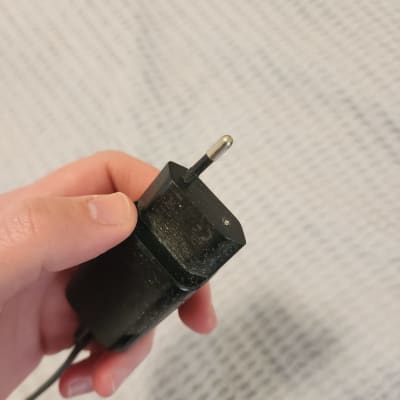 תקע חשמלי מוחזק ביד על רקע בד