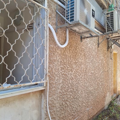 יחידת מיזוג אוויר חיצונית מותקנת על קיר בניין