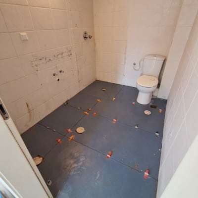 חדר אמבטיה עם שירותים וריצוף בהתקנה