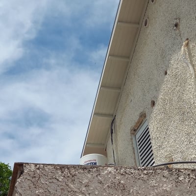 גג עם רעפים לבנים ודלי צבע על הגג