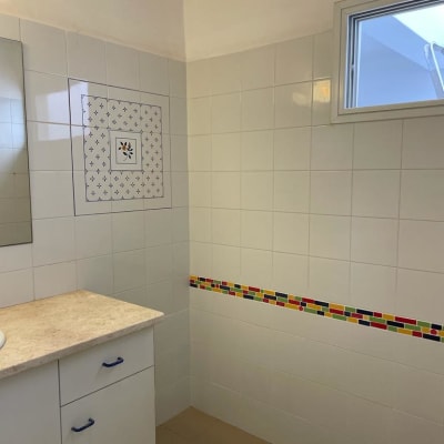 אריחים לבנים עם פס צבעוני על הקיר