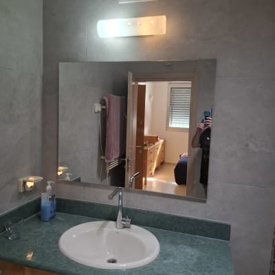 מראה בחדר אמבטיה עם כיור וברז