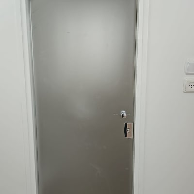 דלת זכוכית עם מסגרת לבנה וקיר לבן