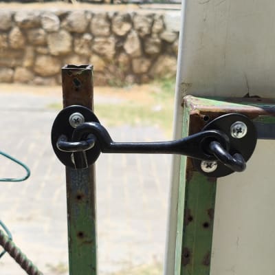 מנעול מתכת על שער ירוק עם ברגים