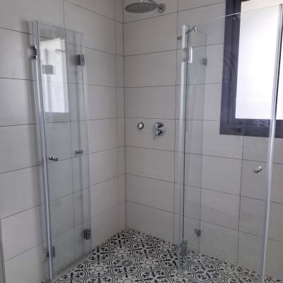 מקלחת עם דלתות זכוכית ורצפה מעוצבת