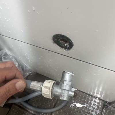 חיבור צינור למכשיר עם מים על הרצפה