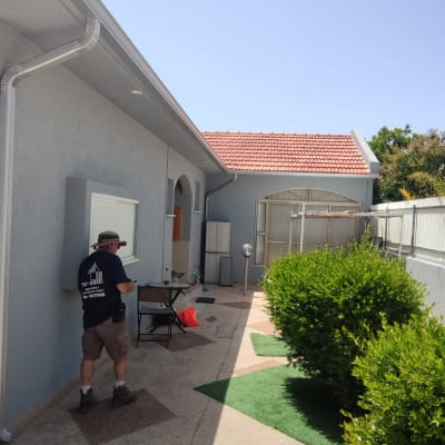 גג רעפים אדום עם מרזב מתכת בצד הבית