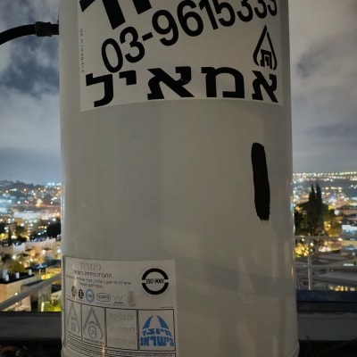 דוד שמש עם פרטי חברה ומספר טלפון על רקע נוף עירוני