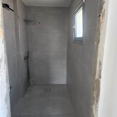 חדר אמבטיה עם אריחים אפורים ומקלחת