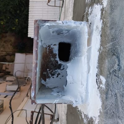 תמונה של צינור עם חומר איטום על קיר חיצוני