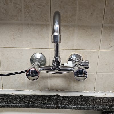 ברז מותקן על קיר עם אריחים