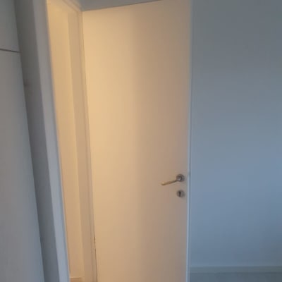 דלת לבנה פתוחה בחדר עם קיר צבוע