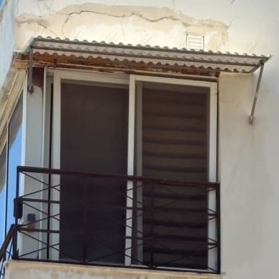 מרפסת עם סדקים בקיר ותקרה מתקלפת