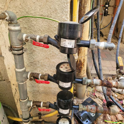 מד מים עם צינורות וברזים אדומים