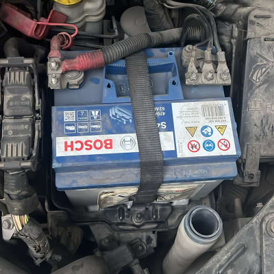 מצבר רכב עם כבלים ומכסה מנוע פתוח