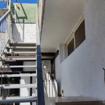 סולם מתכת ליד קיר לבן עם חלון