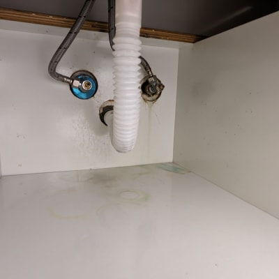 צינור ניקוז לבן מתחת לכיור עם חיבורים