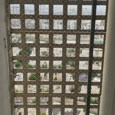 רשת מתכת על חלון למניעת כניסת יונים