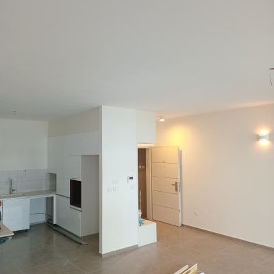 חדר עם קירות צבועים בלבן, כלים על הרצפה