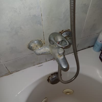 ברז אמבטיה עם צינור מתכת מחובר לקיר