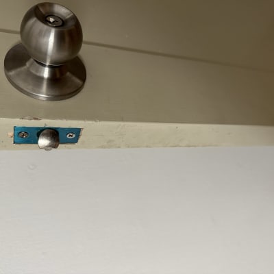 ידית דלת מתכתית ומנעול על דלת עץ