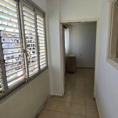 מסדרון עם קירות צבועים בלבן ורצפת אריחים