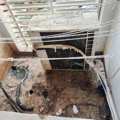 יחידת מיזוג אוויר מלוכלכת עם חוטים ופסולת מסביב