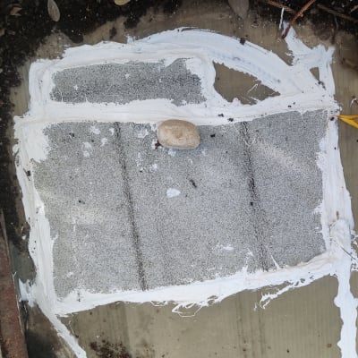 איטום עם חומר לבן על משטח אפור