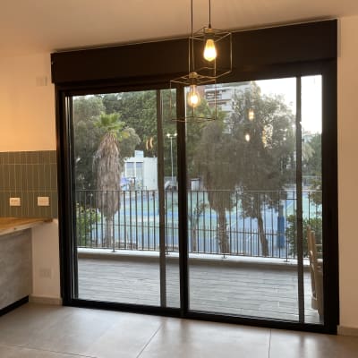 חלון זכוכית גדול עם נוף חיצוני ועצים