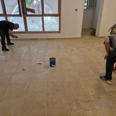 שני אנשים מנקים רצפה עם כלים וחומרי ניקוי