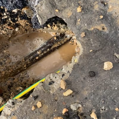 בור בכביש עם מים וצינור חשוף