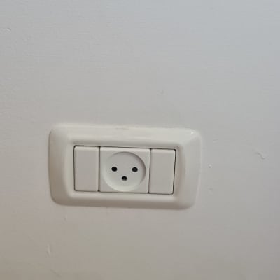 שקע חשמל בקיר לבן עם מסגרת פלסטיק