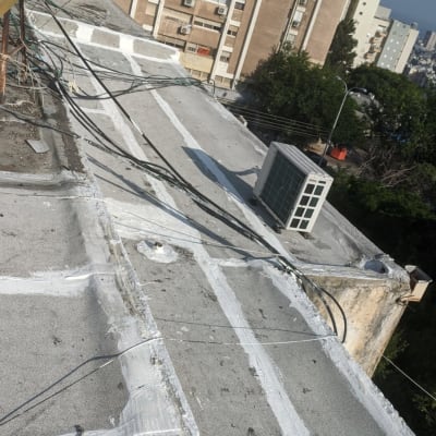 גג עם קווים לבנים לאיטום, צינורות ומזגן