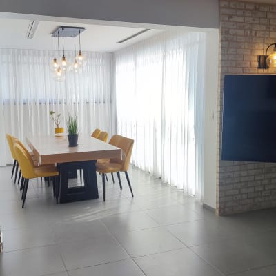 וילונות לבנים תלויים בחדר מואר עם שולחן אוכל