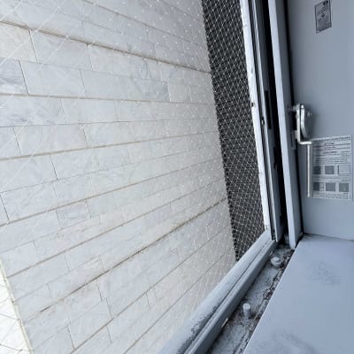 התקנת רשת שקופה נגד יונים על פתח חלון בבניין מגורים