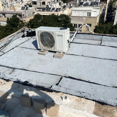 גג אטום עם יריעות ביטומניות ומזגן מותקן