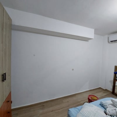 קיר צבוע בלבן עם כלים לצביעה על הרצפה