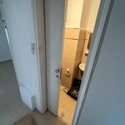 דלת לבנה פתוחה חלקית עם ידית מתכת